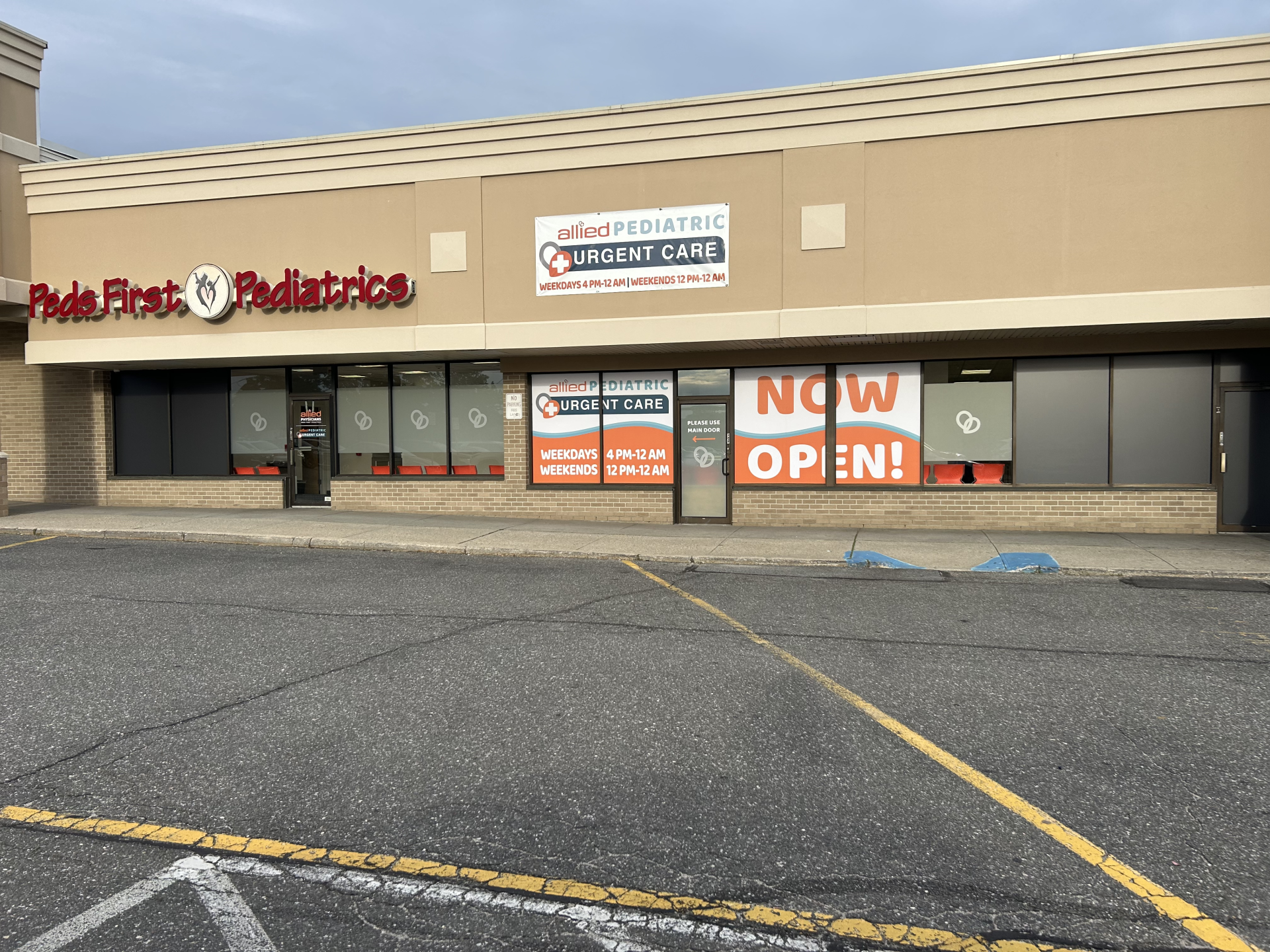 Storefront for Peds First Pediatrics and Allied Pediatric Urgent Care, with signs listing clinic hours and a Now Open banner.